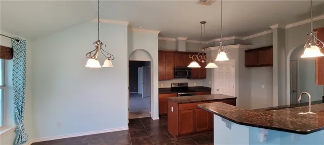 a kitchen with stainless steel appliances granite countertop a sink a stove and a refrigerator