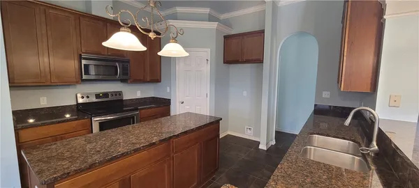 a kitchen with stainless steel appliances granite countertop a refrigerator a stove top oven a sink and dishwasher