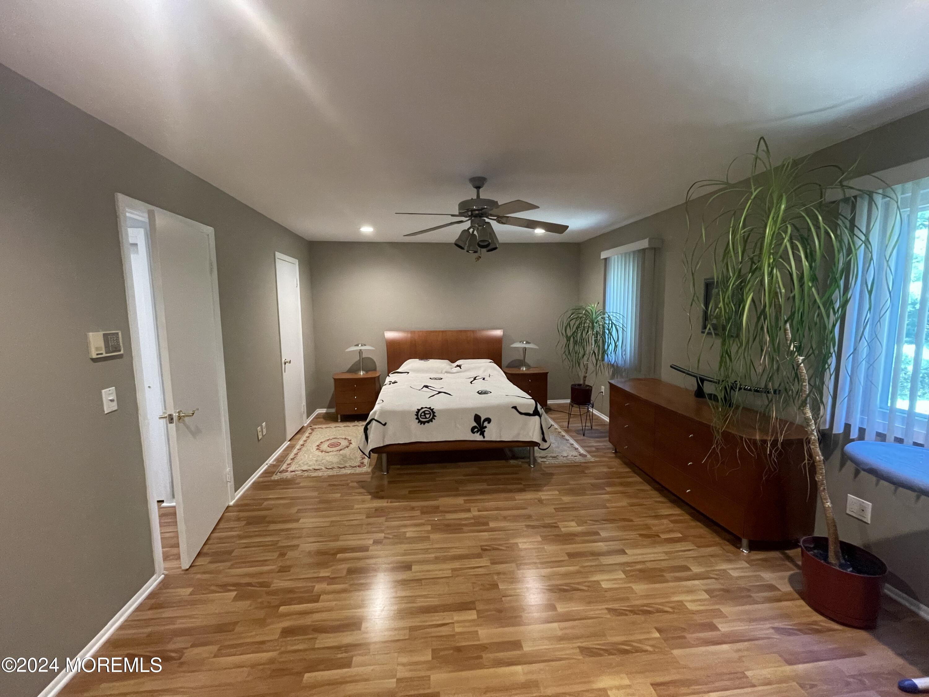4 Rimwood Lane Howell, NJ 07731 - Photo 28 of 44 a spacious bedroom with a bed and a chandelier