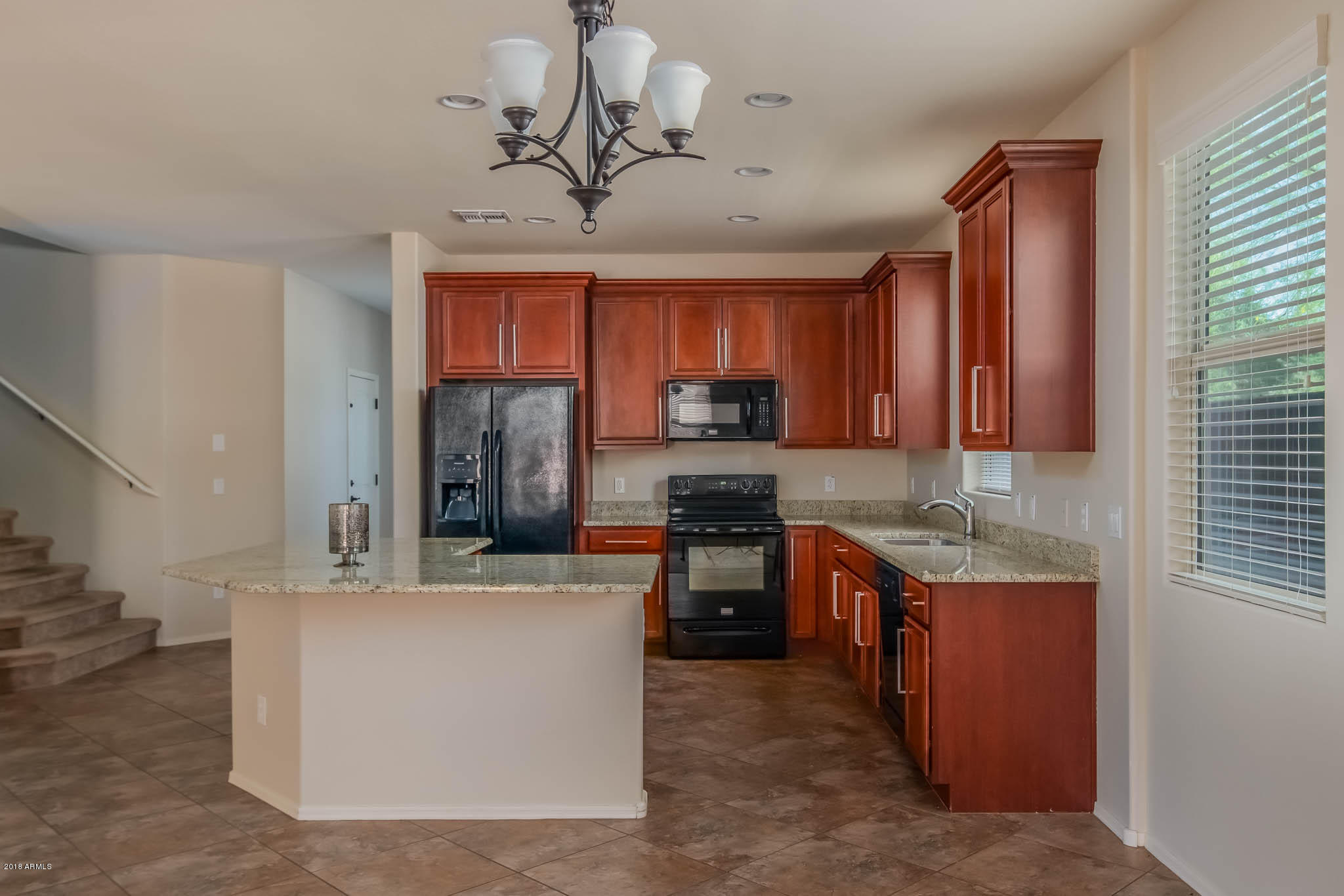 7863 West Redbird Road Peoria, AZ 85383 - Photo 11 of 43 a kitchen with kitchen island granite countertop a sink stainless steel appliances and cabinets