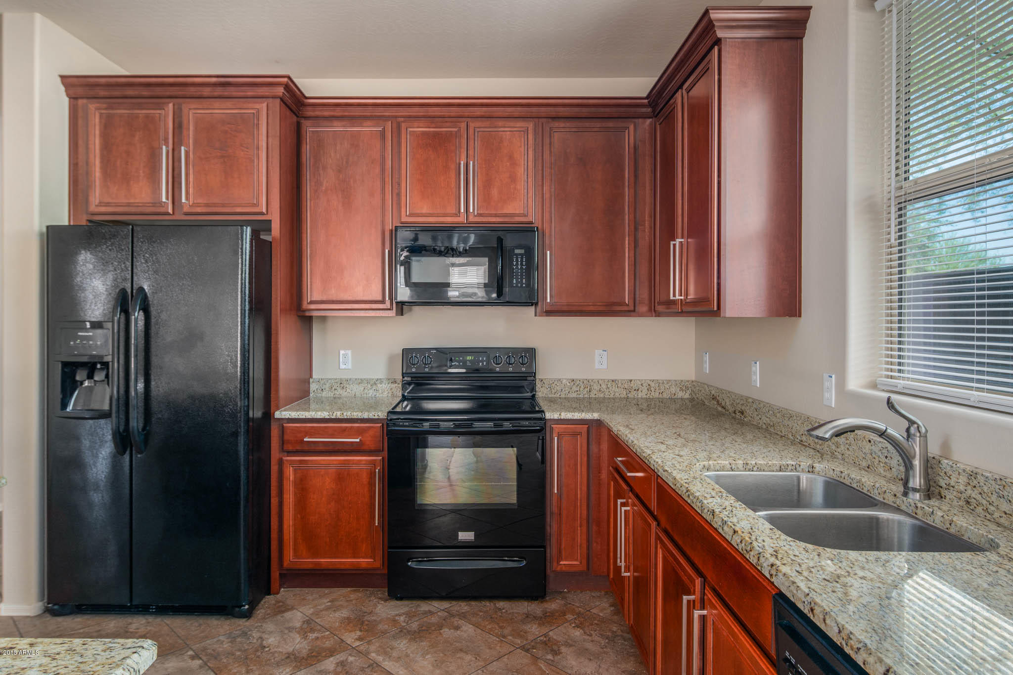 7863 West Redbird Road Peoria, AZ 85383 - Photo 12 of 43 a kitchen with granite countertop a sink stove and refrigerator