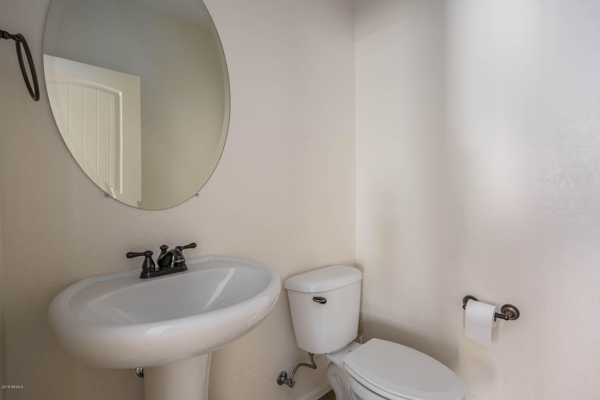 7863 West Redbird Road Peoria, AZ 85383 - Photo 16 of 43 a bathroom with a sink a toilet and a mirror