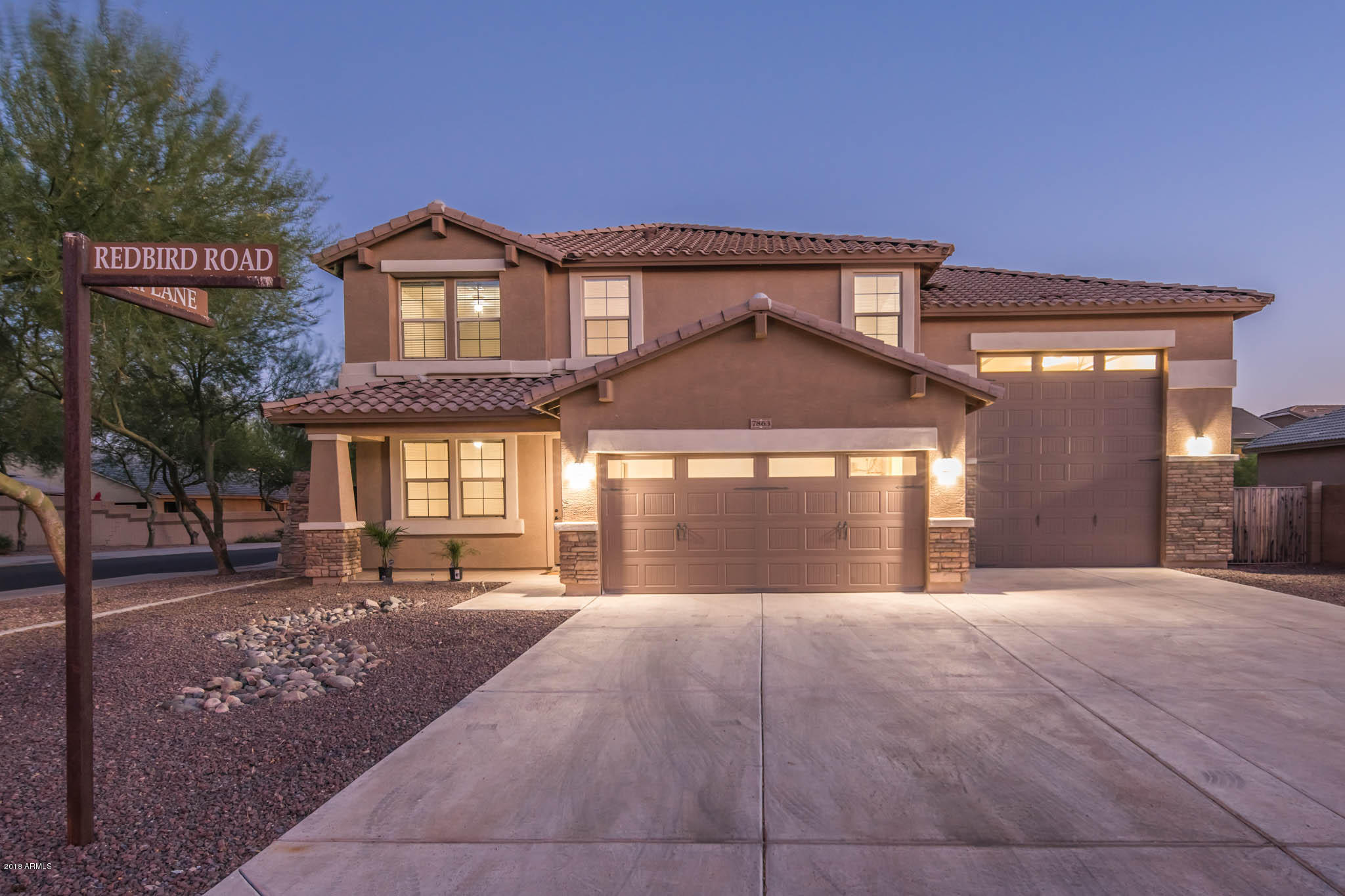 7863 West Redbird Road Peoria, AZ 85383 - Photo 4 of 43 a front view of a house with a yard and garage