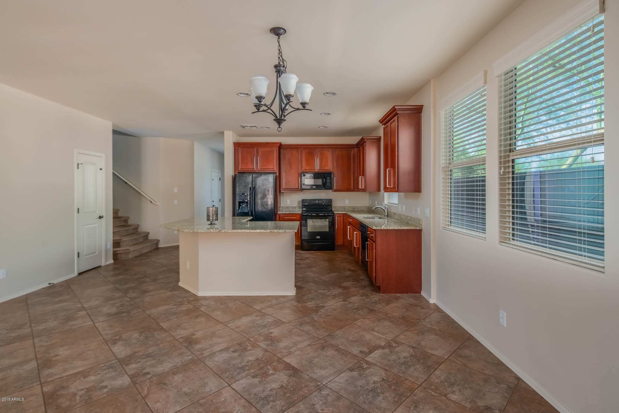 7863 West Redbird Road Peoria, AZ 85383 - Photo 10 of 43 a kitchen with stainless steel appliances granite countertop a stove a refrigerator a sink dishwasher with wooden cabinets and floor