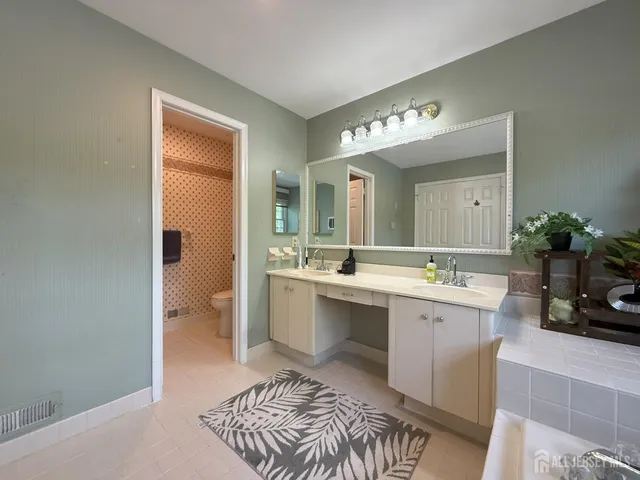 a spacious bathroom with a sink a mirror and a bathtub