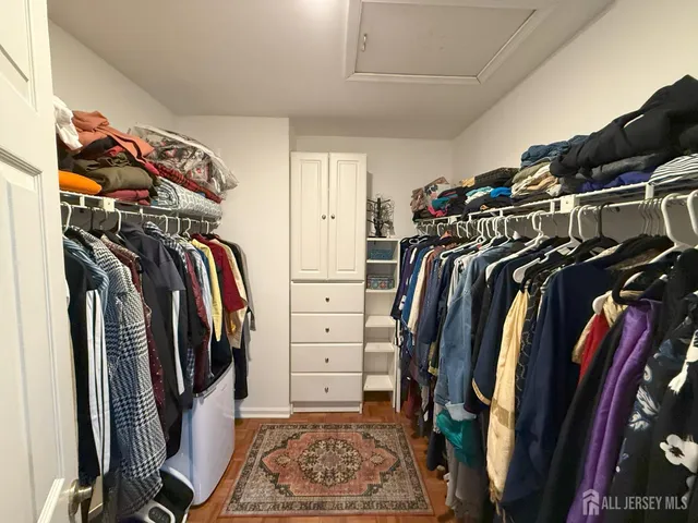a view of walk in closet with clothes