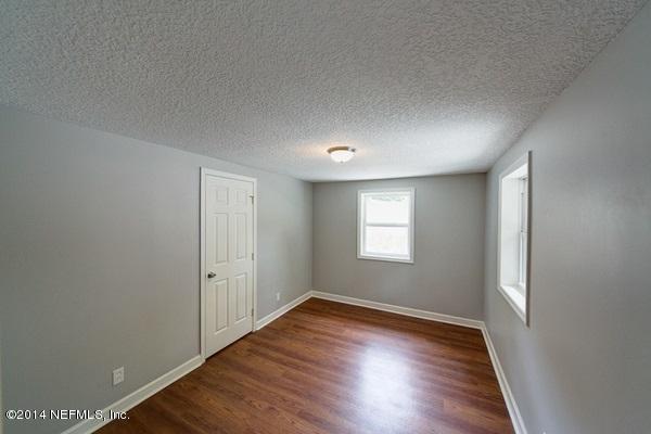 6243 Colgate Road Jacksonville, FL 32217 - Photo 8 of 18 an empty room with wooden floor and windows