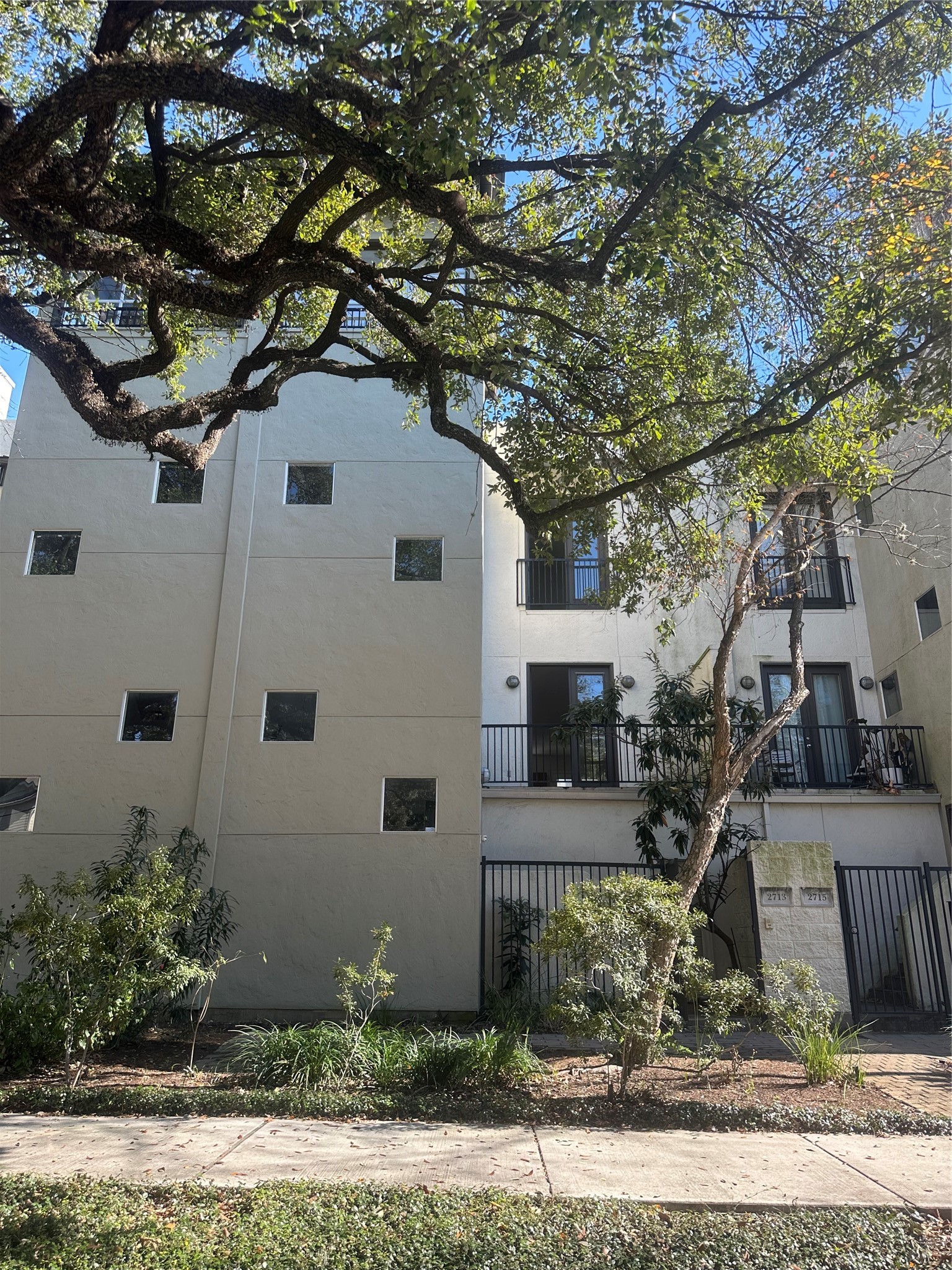 a white house that has a tree in front of it