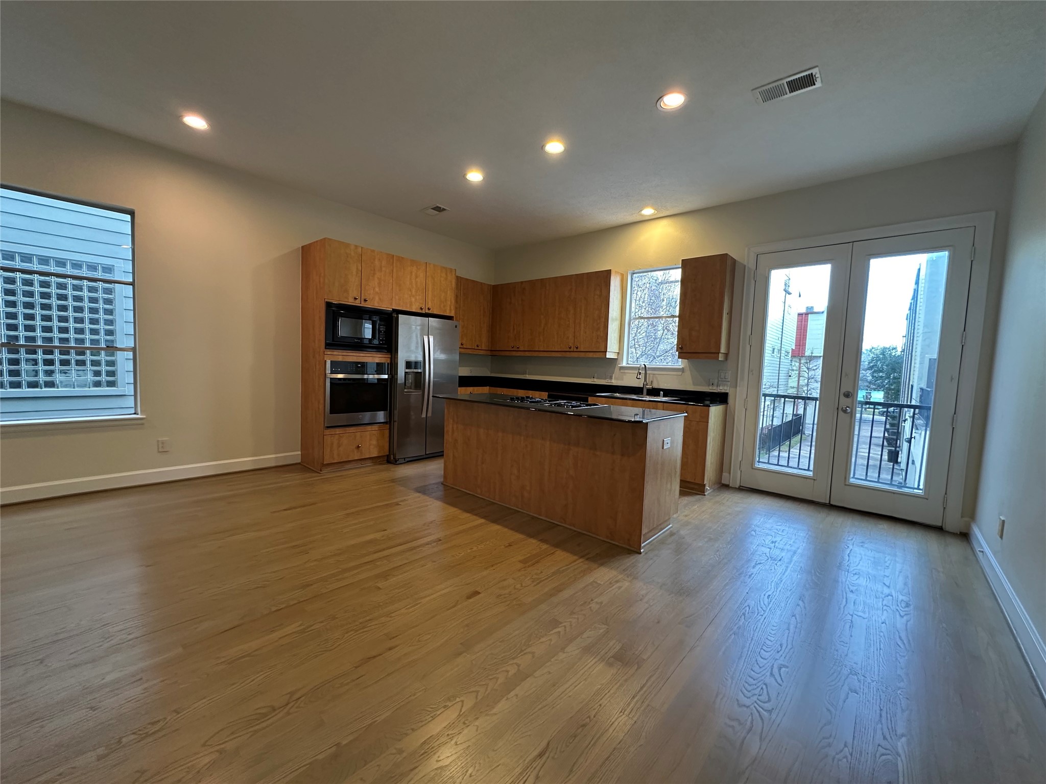 2713 Crawford Street Houston, TX 77004 - Photo 5 of 27 an open kitchen with a refrigerator and wooden floor