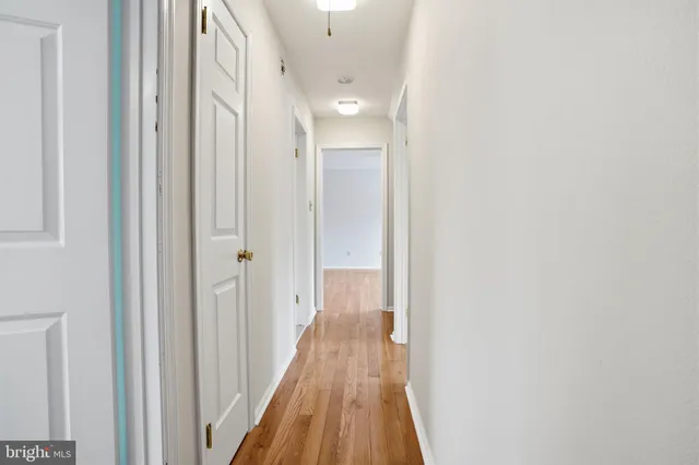 a view of a hallway with wooden floor