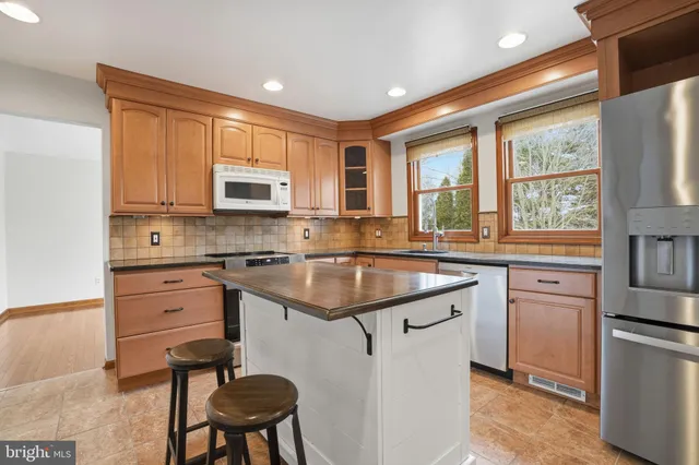a kitchen with stainless steel appliances granite countertop a stove a sink dishwasher and a refrigerator