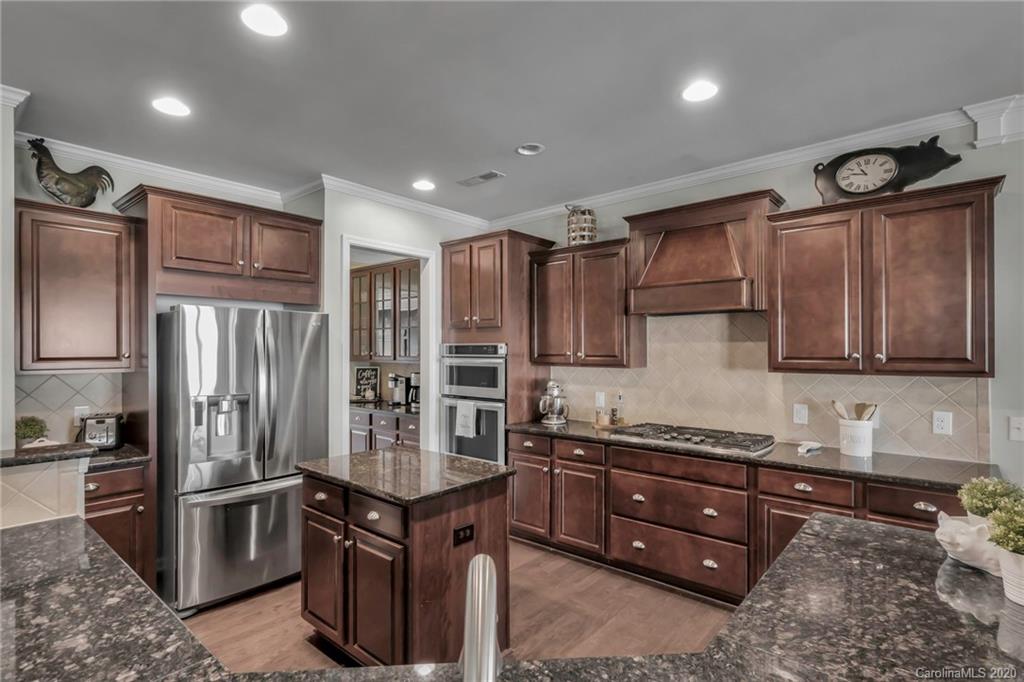 1521 Ridgehaven Road Waxhaw, NC 28173 - Photo 3 of 29 a kitchen with stainless steel appliances granite countertop a stove refrigerator and cabinets
