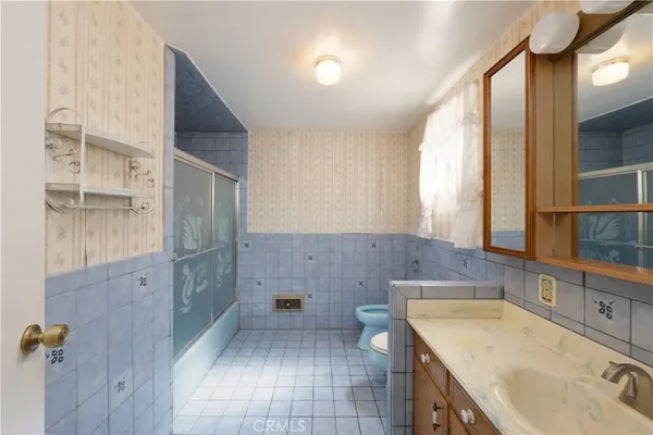a bathroom with a granite countertop sink a toilet and shower