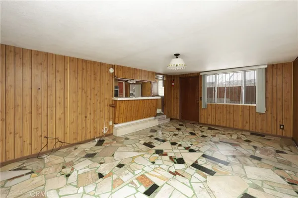 a view of a livingroom with wooden floor and kitchen space