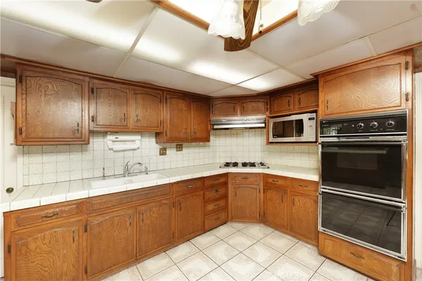 a kitchen with stainless steel appliances granite countertop a sink stove and microwave