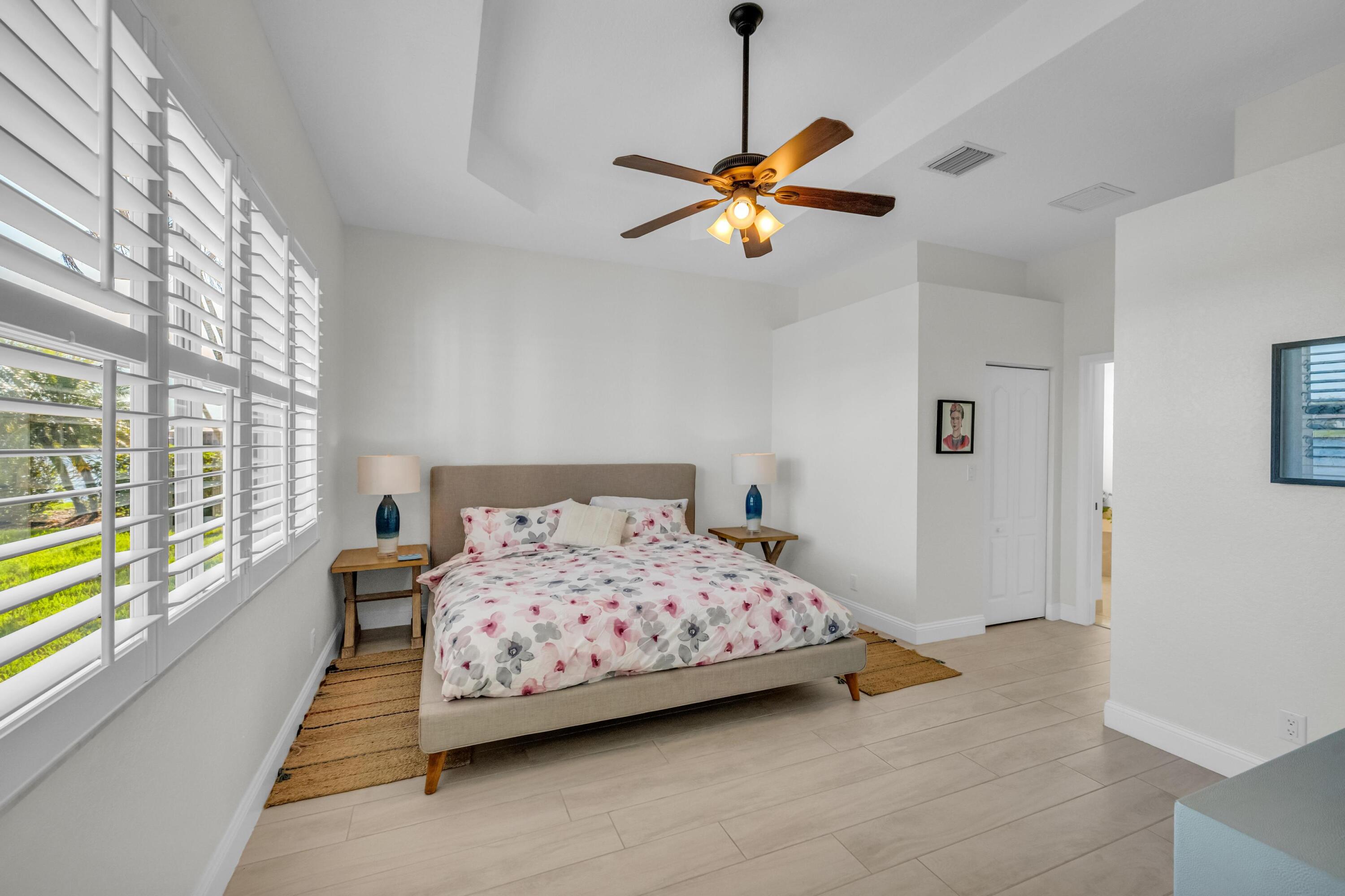 5902 Walnut Park Lane Fort Pierce, FL 34951 - Photo 17 of 45 a bedroom with a bed and a chandelier