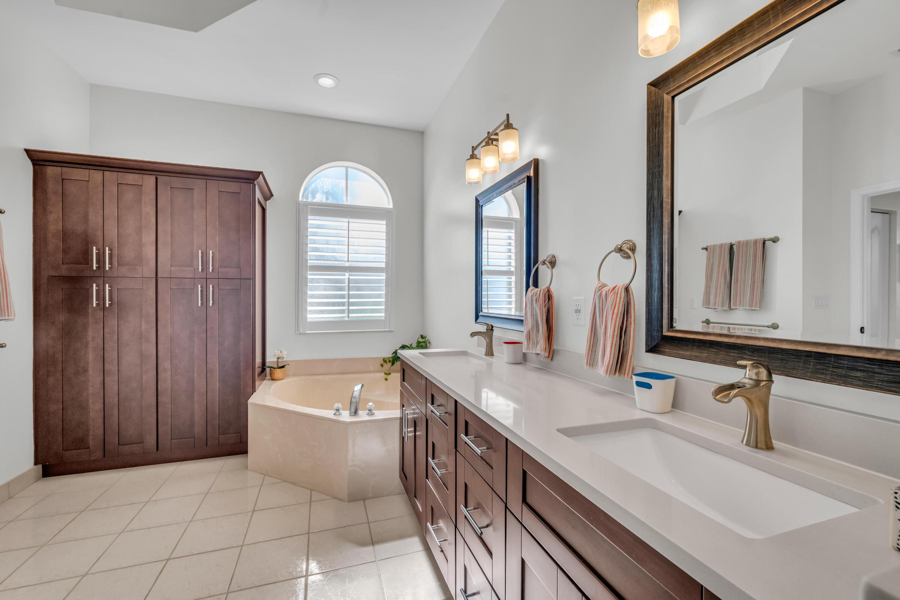 5902 Walnut Park Lane Fort Pierce, FL 34951 - Photo 21 of 45 a bathroom with a double vanity sink a mirror and bathtub