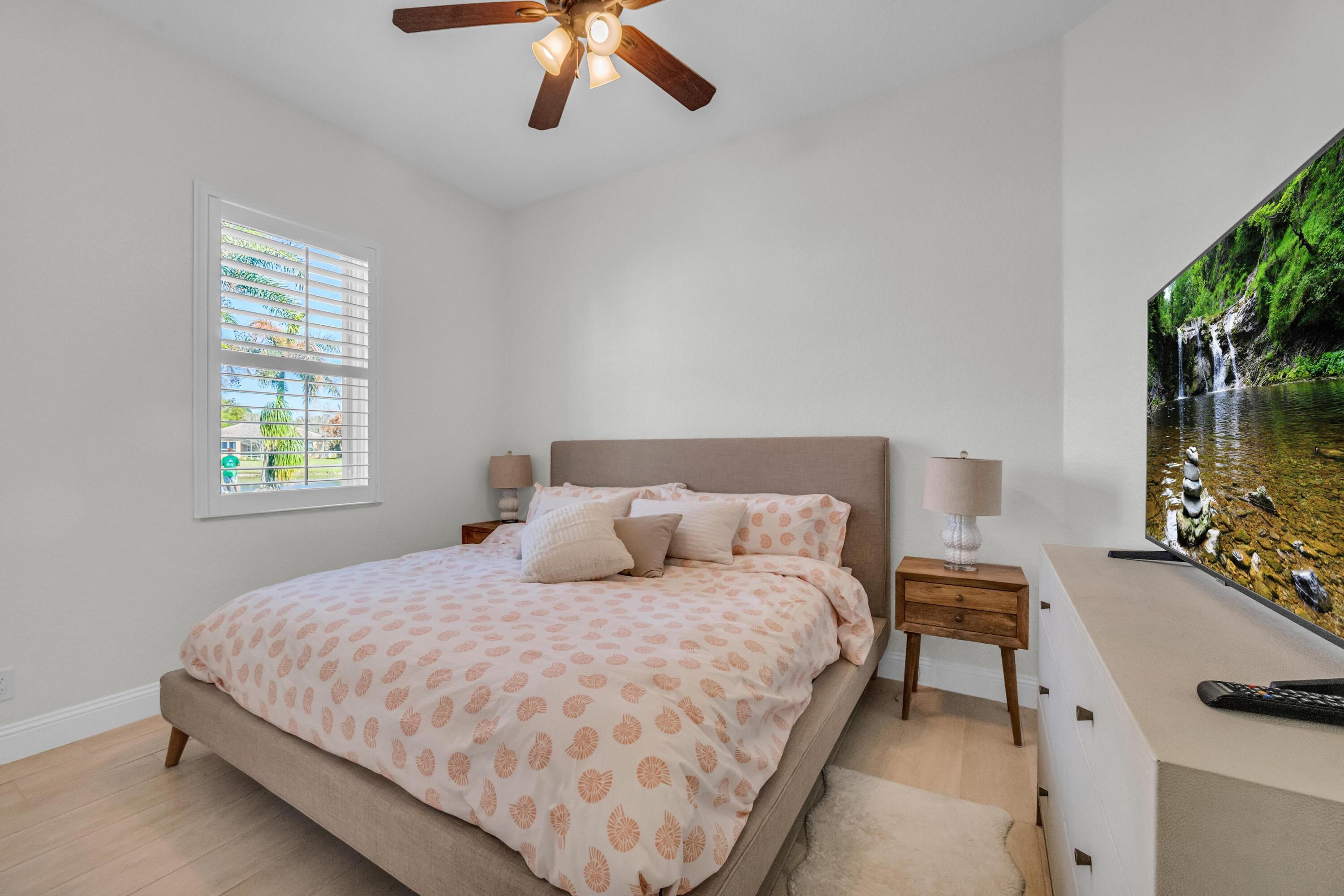 5902 Walnut Park Lane Fort Pierce, FL 34951 - Photo 24 of 45 a bedroom with a bed window and a flat screen tv