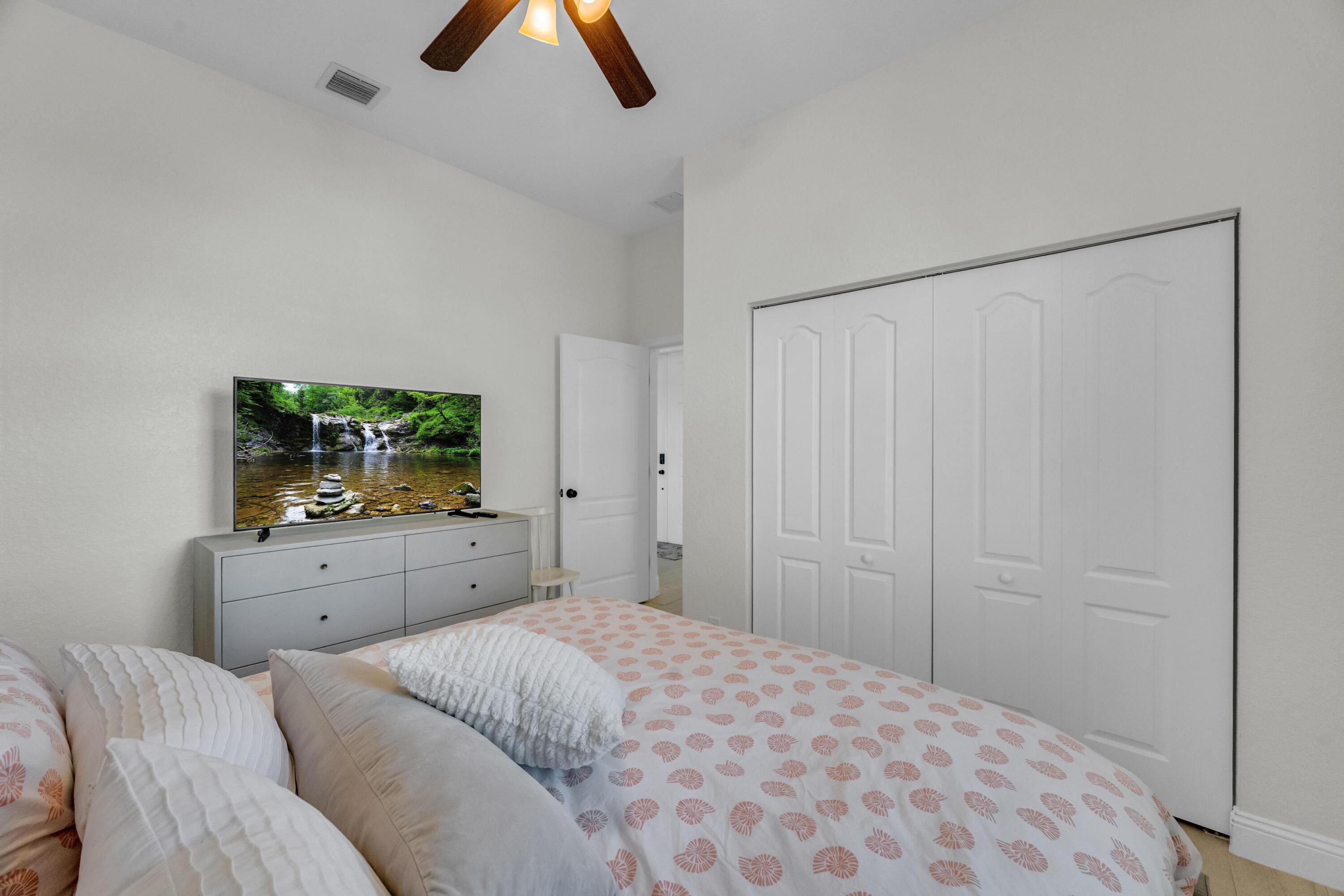 5902 Walnut Park Lane Fort Pierce, FL 34951 - Photo 25 of 45 a bedroom with a bed and a flat screen tv