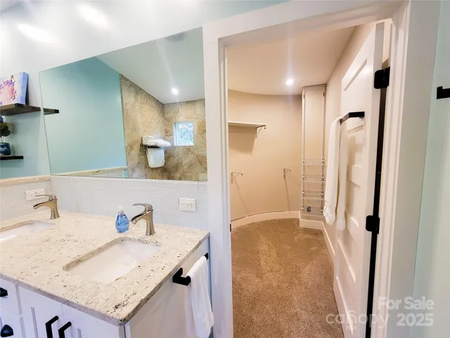 a bathroom with a granite countertop sink a mirror and shower