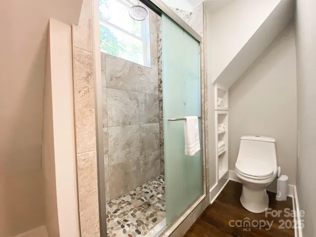 a bathroom with a toilet and a shower