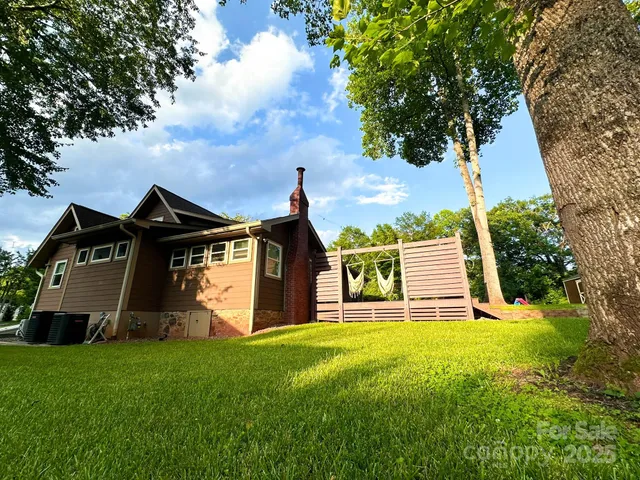a view of a house with brick walls and a yard with plants