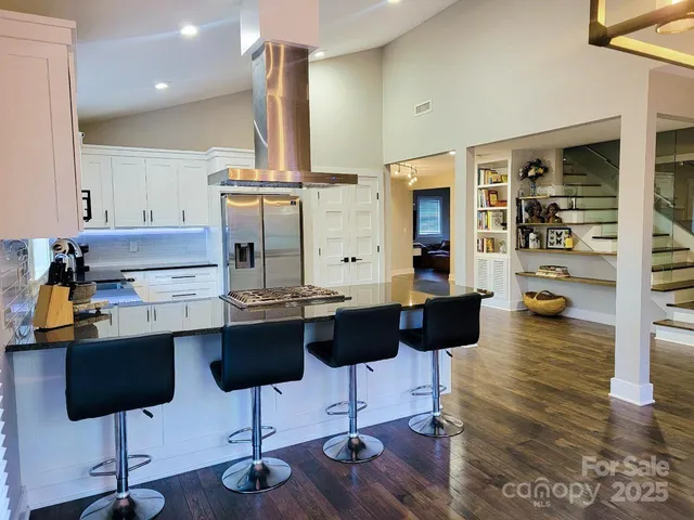 a kitchen with stainless steel appliances kitchen island granite countertop wooden cabinets and a granite counter tops