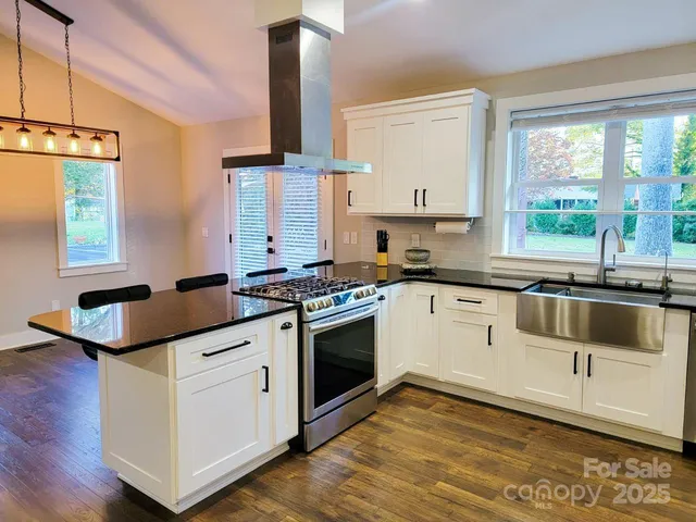 a kitchen with granite countertop a sink and a stove top oven