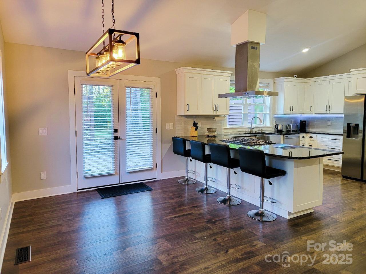 141 Carnegie Road Rutherfordton, NC 28139 - Photo 10 of 48 a kitchen with stainless steel appliances granite countertop a stove top oven a dining table and chairs with wooden floor