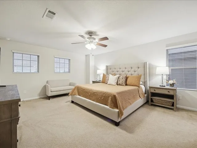 a spacious bedroom with a bed and a chandelier