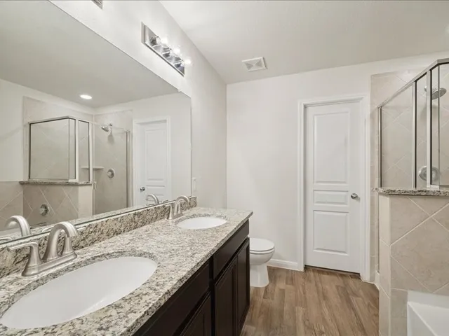 a bathroom with a granite countertop sink a mirror and a shower