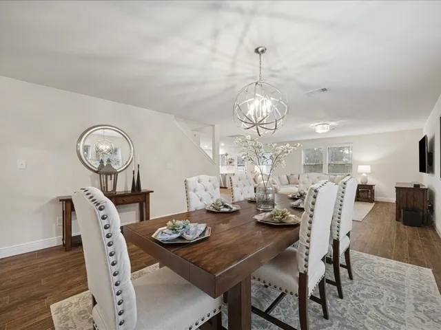 a view of a dining room with furniture a chandelier and wooden floor