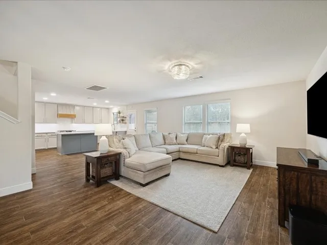 a living room with furniture and a wooden floor