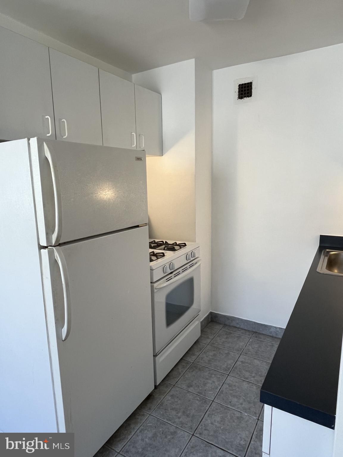 522 21st Street Northwest, Unit 811 Washington, DC 20006 - Photo 17 of 23 a white refrigerator freezer and a stove sitting inside of a kitchen