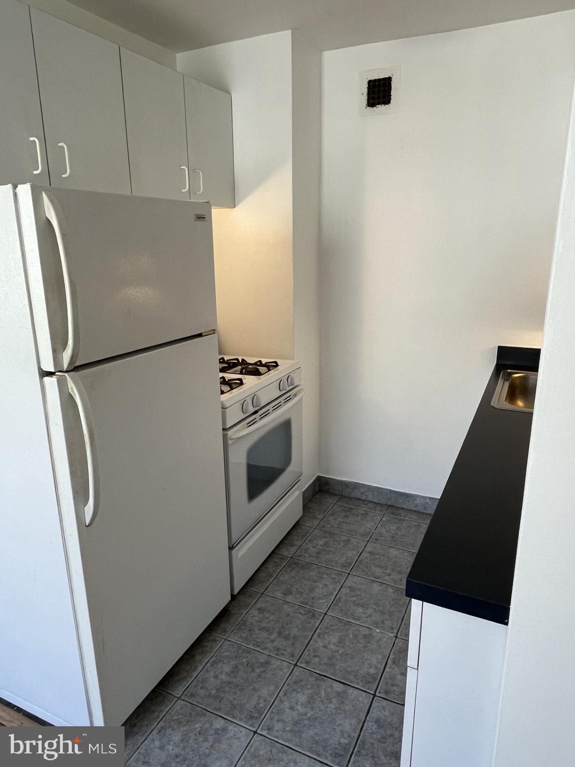 522 21st Street Northwest, Unit 811 Washington, DC 20006 - Photo 19 of 23 a white refrigerator freezer and a stove sitting inside of a kitchen
