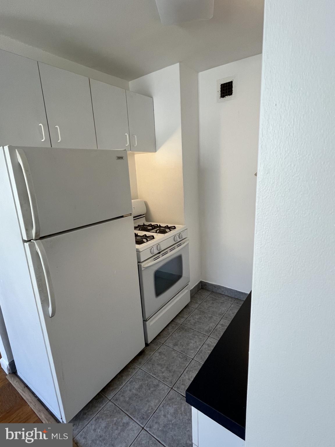 522 21st Street Northwest, Unit 811 Washington, DC 20006 - Photo 20 of 23 a kitchen with white cabinets and white appliances