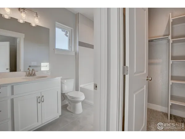 a bathroom with a toilet a sink a vanity and mirror