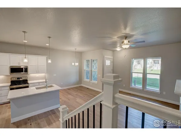 a kitchen with kitchen island granite countertop a sink cabinets and stainless steel appliances