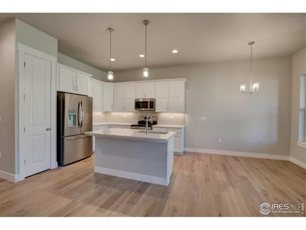 a kitchen with refrigerator cabinets and wooden floor