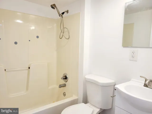 a bathroom with a shower a sink and a toilet