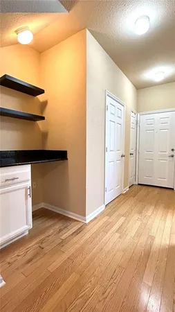a view of empty room with wooden floor and cabinet