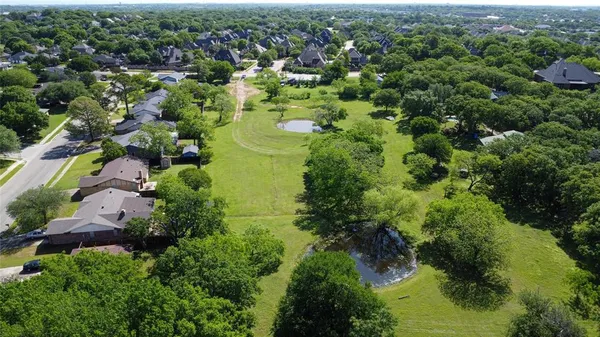 an aerial view of residential house with outdoor space and trees all around