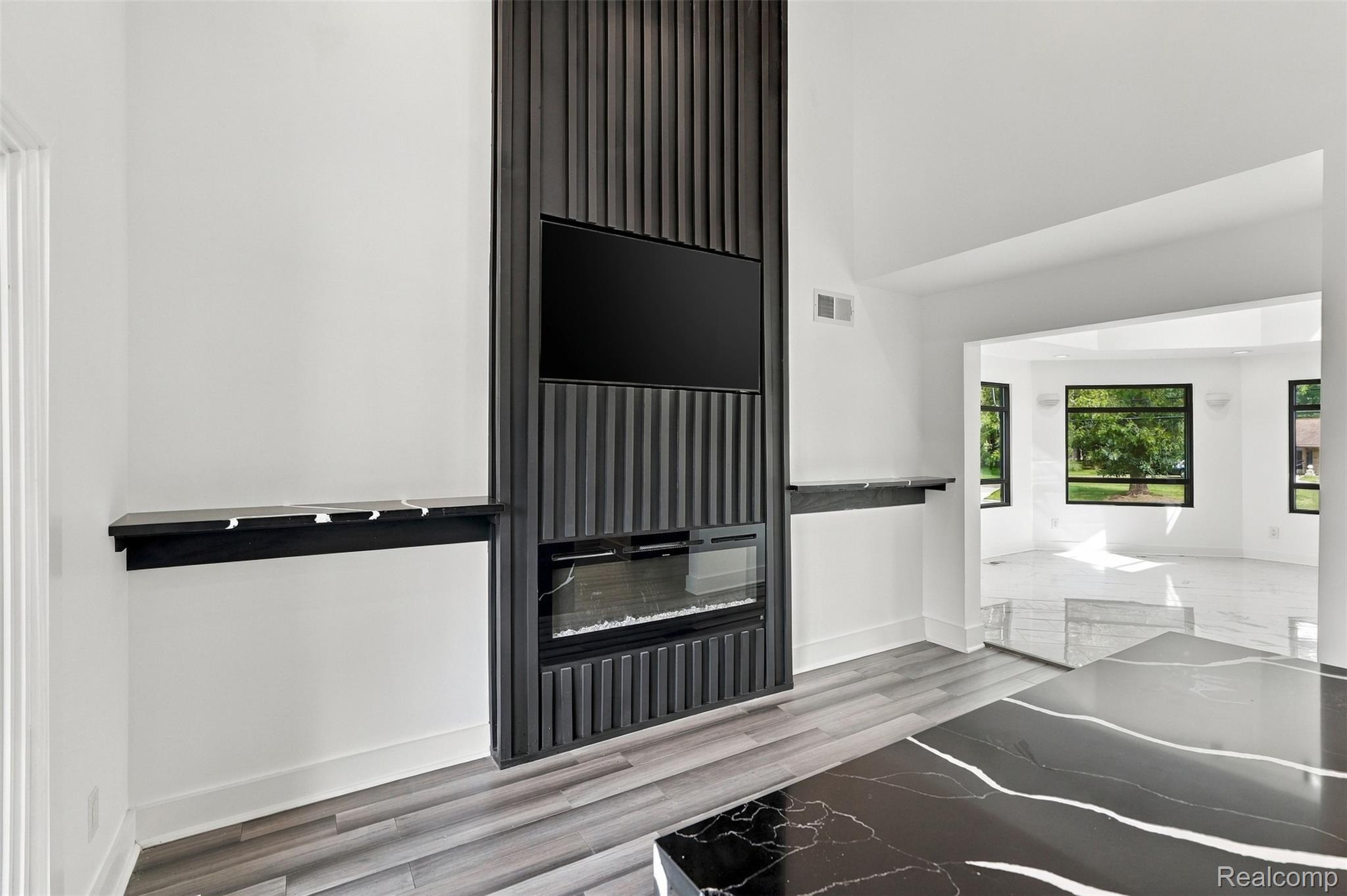 27507 Bell Road Southfield, MI 48034 - Photo 16 of 81 Accent wall with vertical paneling, integrated linear fireplace, and built-in shelving