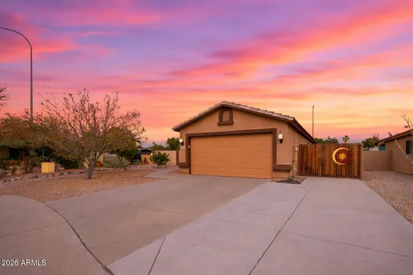 a view of a house with a big yard and large trees