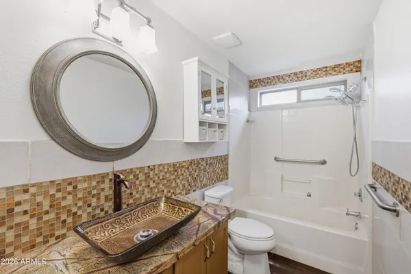a bathroom with a sink a toilet and a mirror