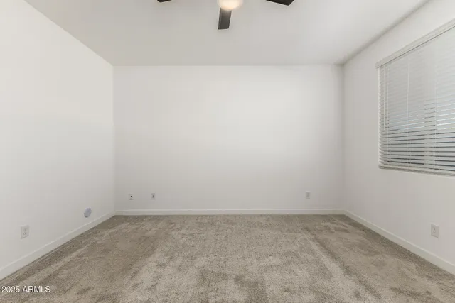 an empty room with chandelier fan