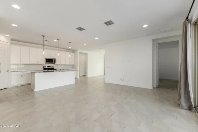 a view of kitchen view with stainless steel appliances refrigerator stove microwave and cabinets