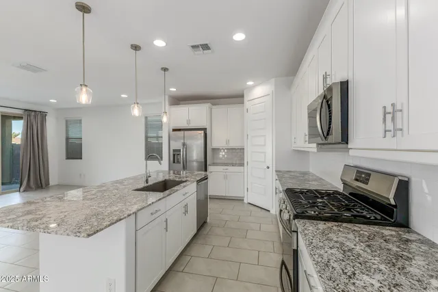 a kitchen with stainless steel appliances granite countertop a sink stove and refrigerator