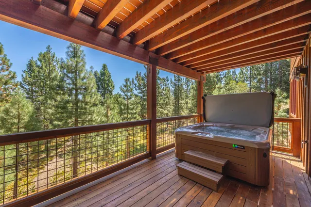 a view of balcony with wooden floor and trees in the background