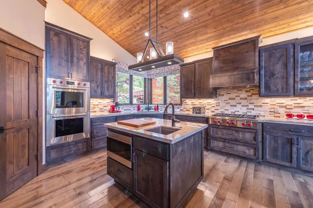 a kitchen with stainless steel appliances granite countertop a stove a sink and a refrigerator